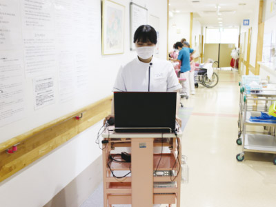 病室へ食事を運んでいる写真